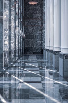 pexels photo 2083961 2083961 1 Modern marble hallway with tall columns and reflective surfaces illuminated by daylight.